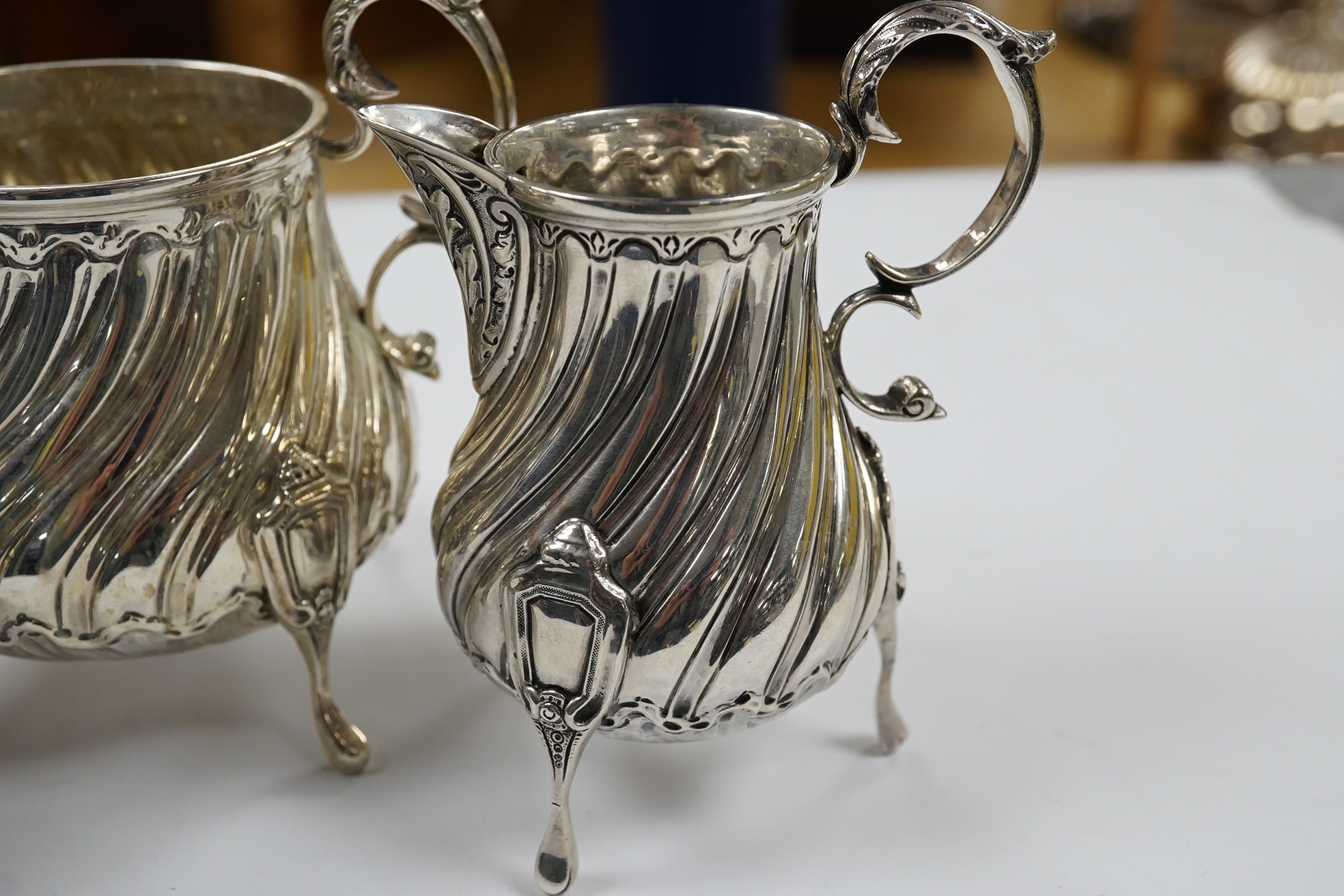 A late Victorian silver cream jug and sugar bowl, by Mappin & Webb, London, 1900 and an earlier William IV silver cream jug, London, 1835, 16.1oz. Condition - fair to good